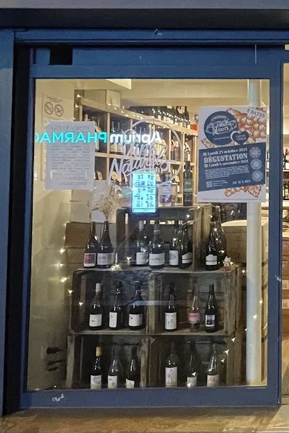 La vitrine de gauche le soir, bouteilles rangées sur des caisses en bois